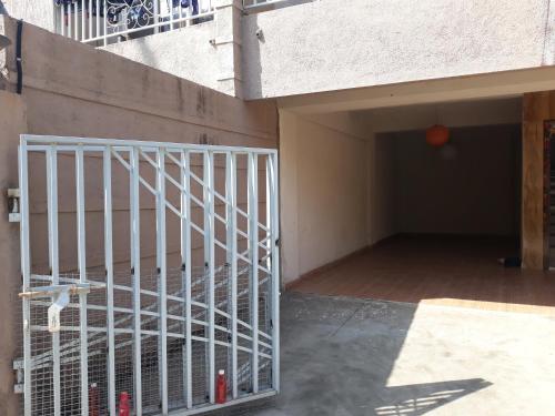 a garage with a white gate next to a building at Spanish villa , chinchoti in Bapane