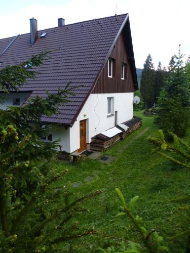 a large white house with a black roof at Ubytování Lyžařská škola in Kubova Huť