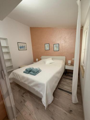 Un dormitorio con una cama blanca con toallas. en Apartman Etta - Šišan, en Šišan