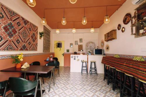 伊宁Good Morning International Chain Hostel Of Yining City的有酒吧和桌椅的餐厅