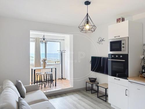 Il comprend un salon blanc avec un canapé et une cuisine. dans l'établissement Bay View Studio climatisé 4 pers vue mer by LaConciergerie13, à La Ciotat