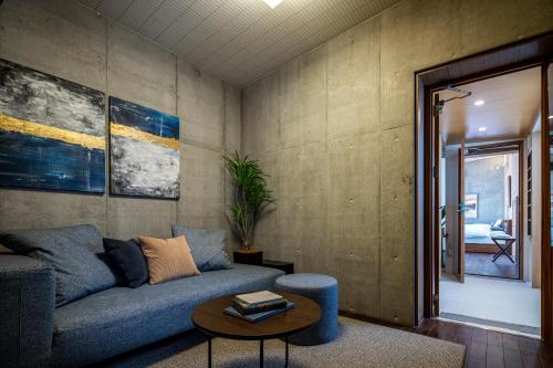 a living room with a blue couch and a table at 葉山Yashiro - 小型犬1匹まで一緒に泊まれる一棟貸し別荘 in Hayama