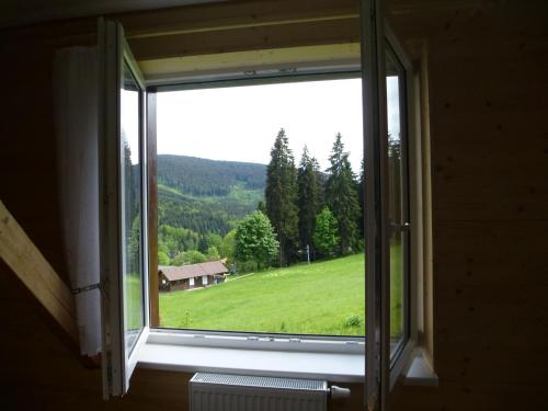 an open window with a view of a green field at Ubytování Lyžařská škola in Kubova Huť