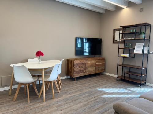 a dining room with a table and chairs and a tv at La casa ai Laghetti in Montorio Veronese
