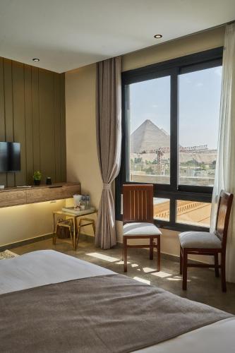 a hotel room with a bed and a large window at Pyramids Secret Hotel in Cairo