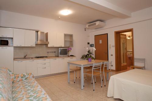 a kitchen and living room with a table and chairs at Residence Cà D'oro in Lido di Jesolo