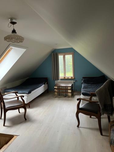 a attic room with two beds and a window at Skräddarhuset - Lilla huset in Bonnarp