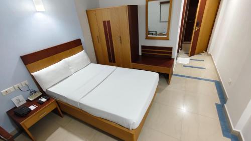 a bedroom with a bed and a table and a mirror at Hyson heritage calicut in Kozhikode
