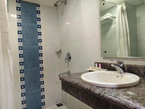 a bathroom with a sink and a mirror at Hyson heritage calicut in Kozhikode