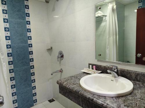 a bathroom with a sink and a mirror at Hyson heritage calicut in Kozhikode