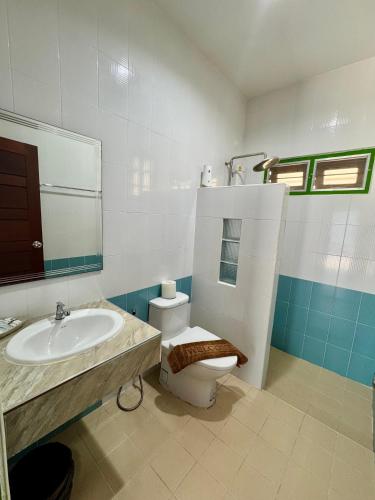 a bathroom with a toilet and a sink at Pohnphansa Boutique Hotel in Narathiwat