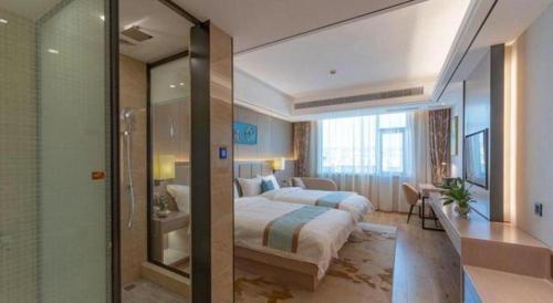 a hotel room with a bed and a bathroom at GreenTree Eastern Dali Railway Station Hotel in Dali