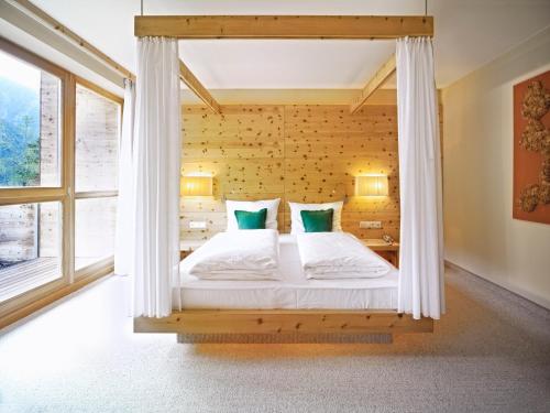 a bed in a room with a window at Arosea Life Balance Hotel in Santa Valburga St. Walburg