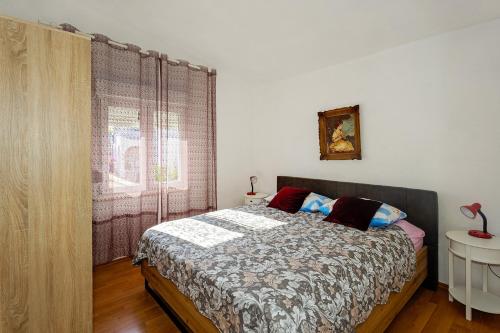 a bedroom with a bed and a window at Spacious Terrace Apartments in Rogoznica