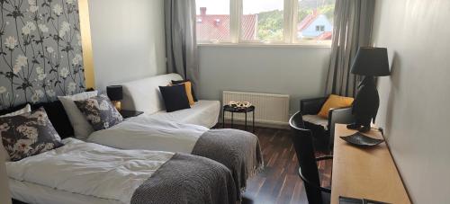 a living room with a bed and a desk and a window at Nösundsgården Hotell & Vandrarhem in Nösund