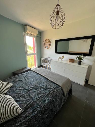 a bedroom with a bed and a large tv on the wall at Appartement ds résidence avec piscine Mauguio Carnon in Mauguio