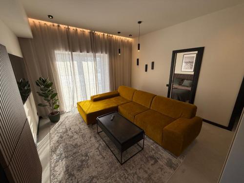 a living room with a yellow couch and a table at GU DESIGN apartments in Saldus