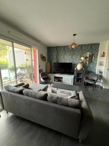 a living room with a couch and a table at Appartement ds résidence avec piscine Mauguio Carnon in Mauguio
