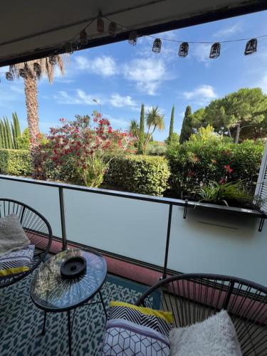 a balcony with a table and chairs and plants at Appartement ds résidence avec piscine Mauguio Carnon in Mauguio