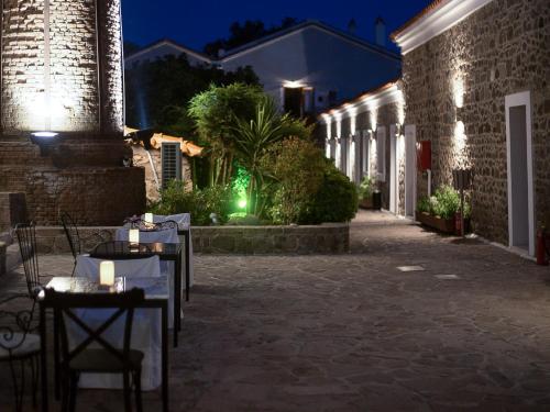 an empty courtyard at night with tables and lights at Olive Press Hotel in Mithymna