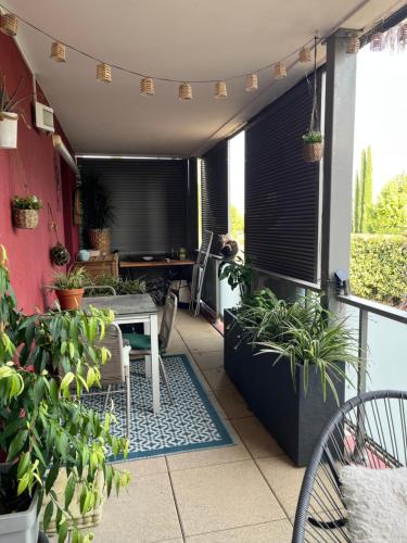 a patio with plants and a table on a balcony at Appartement ds résidence avec piscine Mauguio Carnon in Mauguio