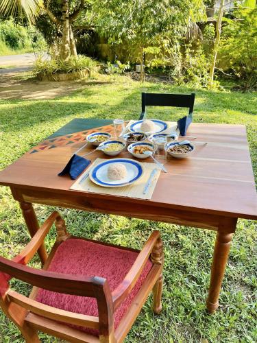 a wooden table with bowls of food on it at Muthu Nila villas- Mirissa in Mirissa