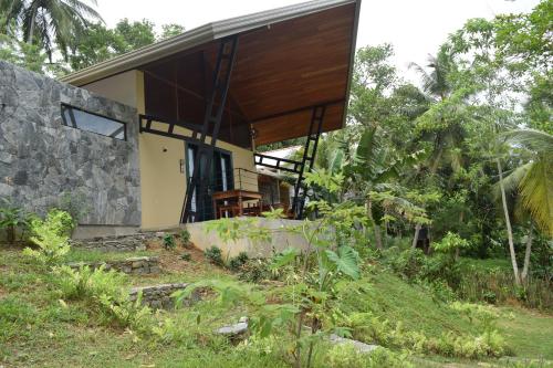 a house on a hill with a stone wall at Muthu Nila villas- Mirissa in Mirissa