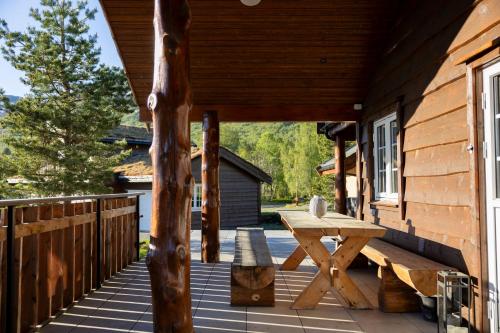 a wooden deck with a picnic table on the side of a cabin at Family Lodge in Stryn in Stryn