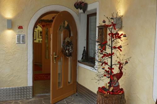 Un pasillo con una puerta y un árbol de Navidad en Alpin Apartments Colfosco, en Colfosco