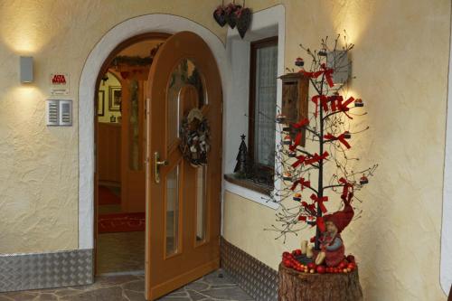 a hallway with a door and a christmas tree at Alpin Apartments Colfosco in Colfosco
