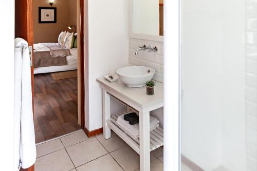 a bathroom with a white sink and a mirror at Leipzig Country House & Winery in Nuy