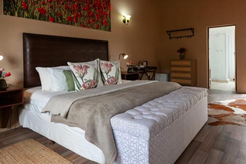 a bedroom with a large bed with a blanket on it at Leipzig Country House & Winery in Nuy