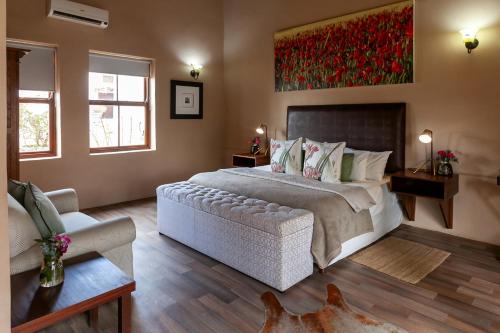 a bedroom with a large bed and a couch at Leipzig Country House & Winery in Nuy