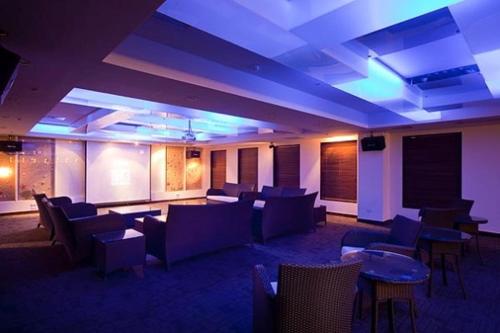 a large room with couches and tables and blue lights at Fullon Resort Kending in Eluan