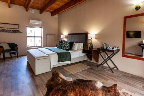 a bedroom with a bed and a table and a mirror at Leipzig Country House & Winery in Nuy