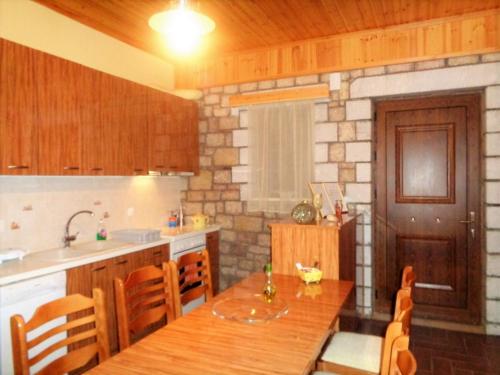a kitchen with a wooden table and a counter top at Menina Farm Kalamata Countryside in Perivolákia