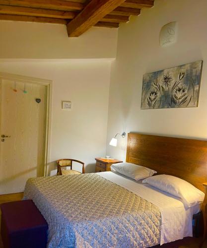 a bedroom with a large bed with a wooden headboard at Affittacamere LA TENUTA in Spello