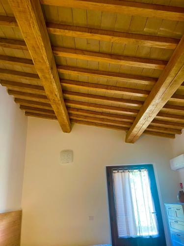 a room with wooden ceilings and a window at Affittacamere LA TENUTA in Spello