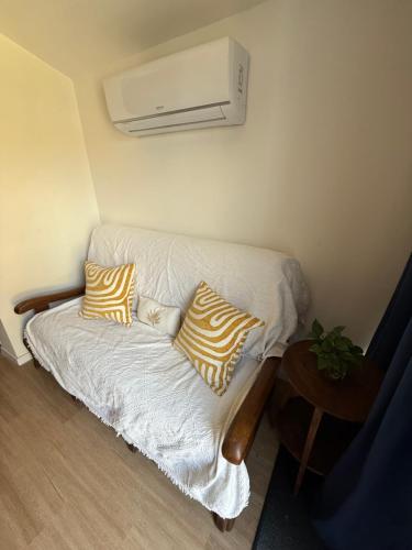 a couch with two pillows on it in a room at La maisonnette confort de Tari et Nicolas in Juillan
