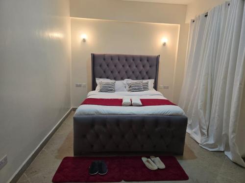 una camera da letto con un letto grande con due cuscini di lovely, cozy 2 bedroom apartment a Kericho