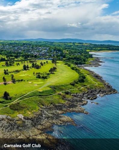 an aerial view of a golf course next to the water at Loughview Cottage in Bangor