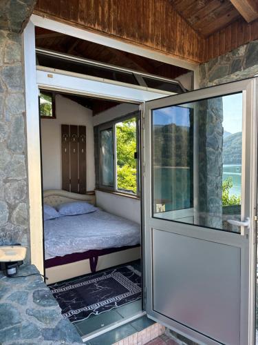 a room with a bed and a window at Vikendica Plavi Mir in Konjic