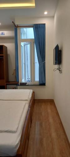 a bedroom with a bed and a window with a tv at Tuy Hòa Beach Hotel - Căn hộ du lịch in Tuy Hoa