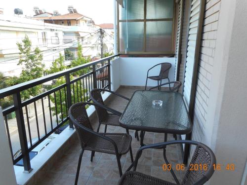 a balcony with four chairs and a table on it at Dimitra's Apartments in Olympiaki Akti