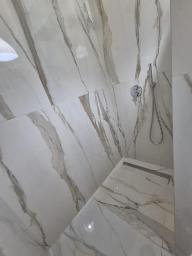 a bathroom with marble walls and a shower at Casa Baia Tramonto in Patù