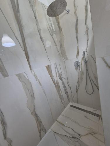 a bathroom with marble walls and a shower at Casa Baia Tramonto in Patù