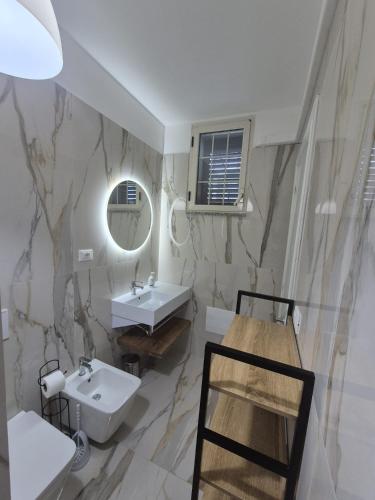 a bathroom with a sink and a mirror at Casa Baia Tramonto in Patù