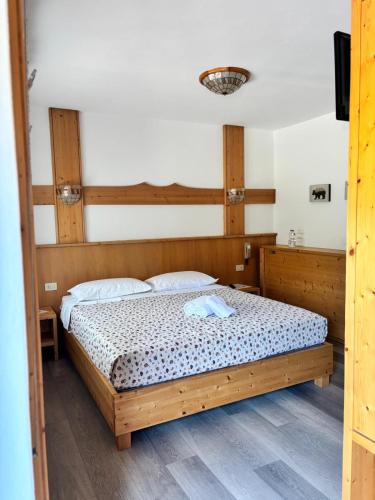 a bedroom with a wooden bed in a room at Chalet Monte Coston in Lastebasse