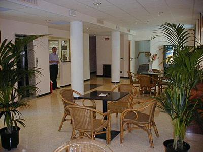 a person standing in a room with tables and chairs at Residence Cà D'oro in Lido di Jesolo