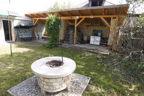 a backyard with a brick fire pit in the grass at Total Relax Apartmanház in Bogács